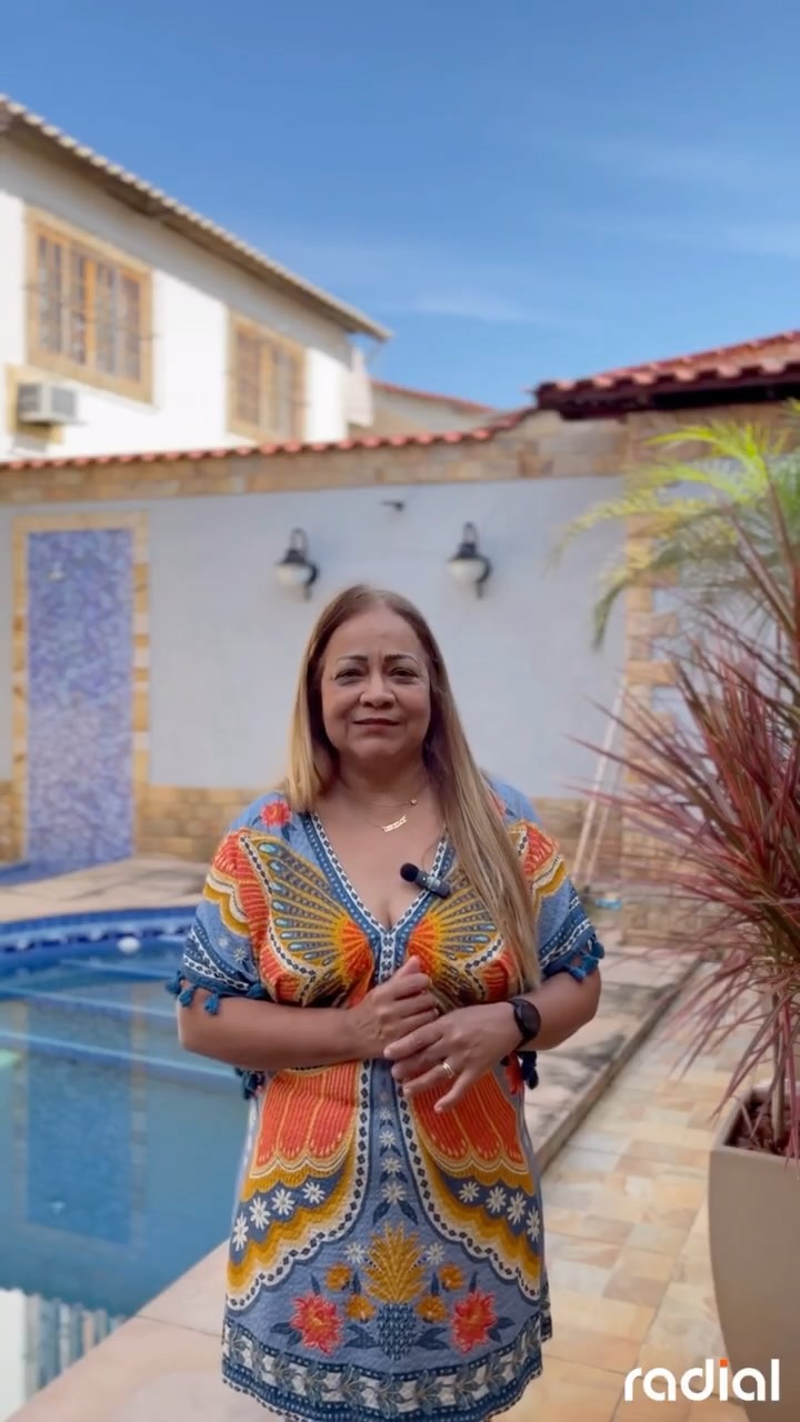 Dona Célia em frente à sua casa com sistema de energia solar da Radial